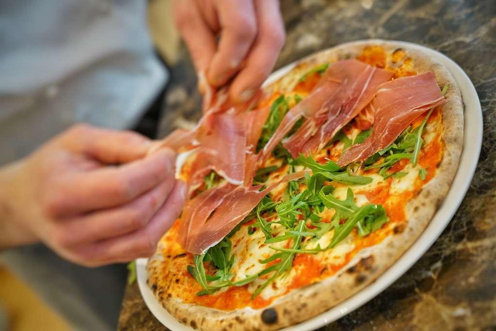 Vila Vita Rosenpark Marburg Exterior foto Pizza being topped with prosciutto